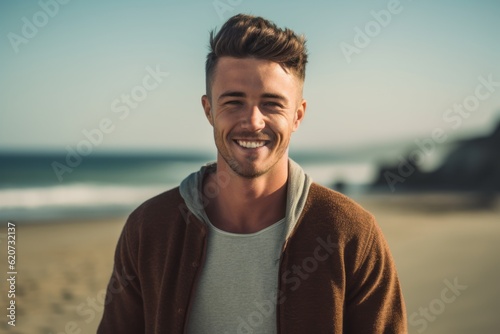 Portrait of smiling young man standing at beach on a sunny day
