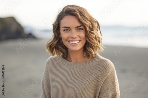 Portrait of smiling young woman standing on beach at the day time