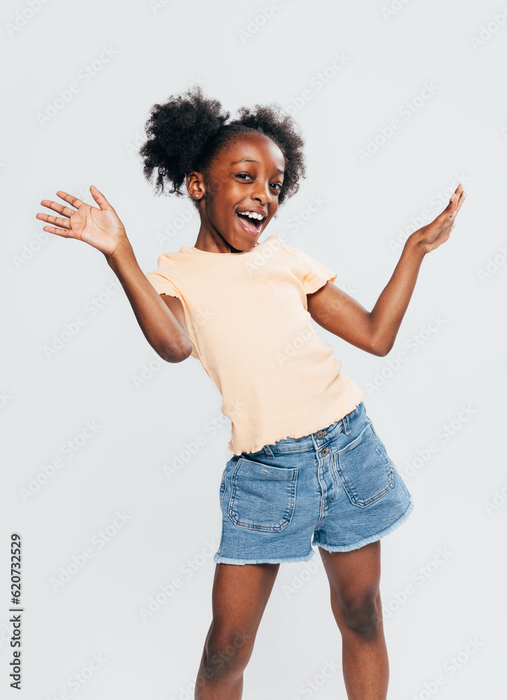 Cheerful black girl with raised arms in studio Cheerful black girl with raised arms in studio