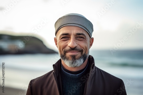 Portrait of a smiling mature man standing by the sea at the beach © Eber Braun