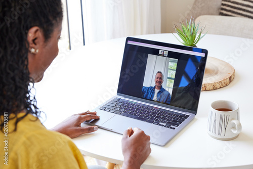 Black woman doing a zoom call with work colleague on computer photo