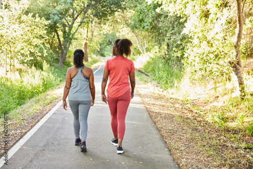 Black girlfriends walking and exercising on a trail together photo