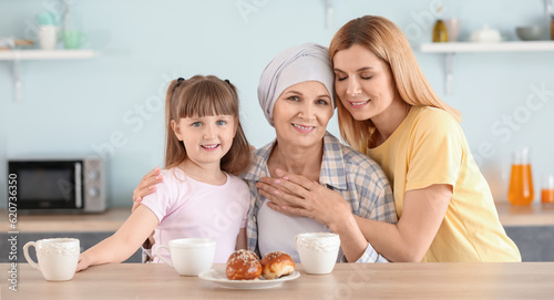 Mature woman after chemotherapy with her family in kitchen at home