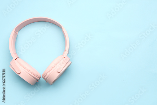 Modern pink headphones on blue background
