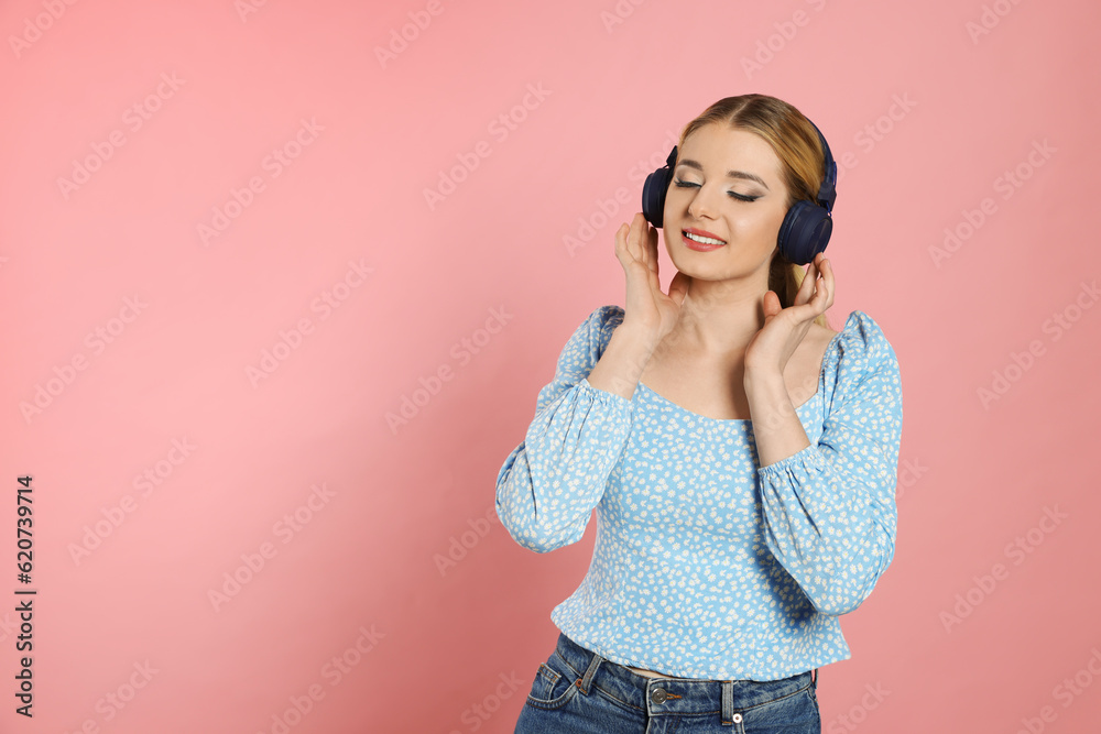 Happy woman in headphones enjoying music on pink background. Space for text Happy woman in headphones enjoying music on pink background. Space for text