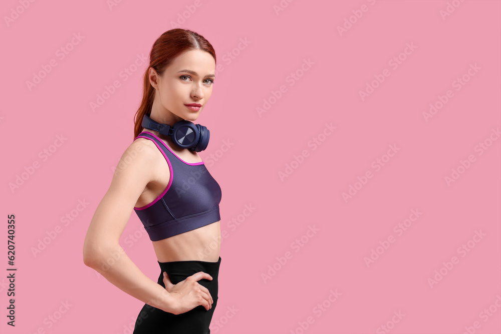 Obraz premium Woman in sportswear and headphones on pink background, space for text