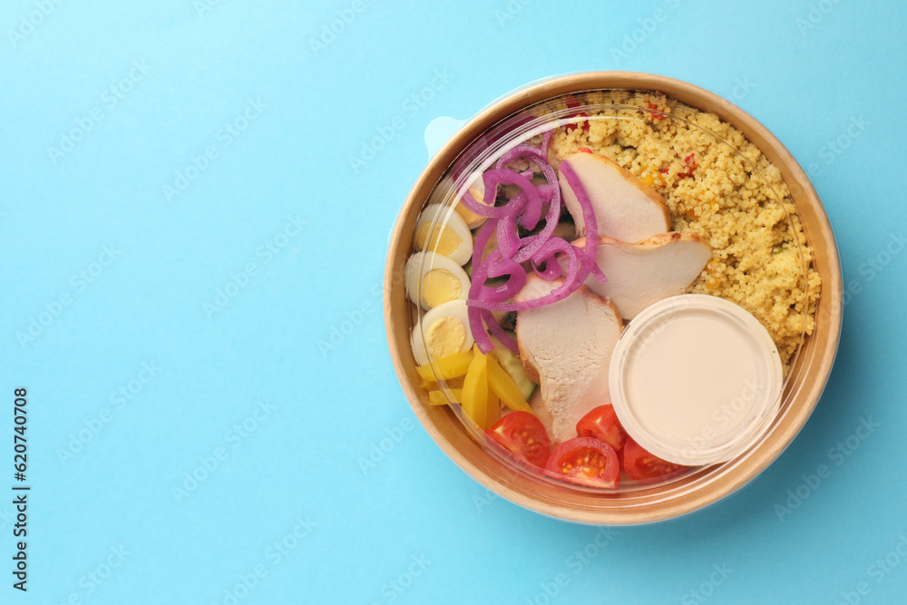 Tasty food in container on light blue background, top view. Space for text Tasty food in container on light blue background, top view. Space for text