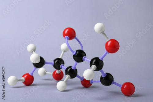 Molecule of vitamin C on light grey background. Chemical model