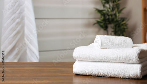 White clean towels on wooden table in bathroom. Space for text © Uuganbayar