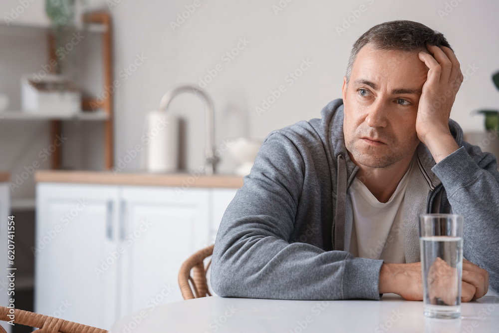 Fototapeta premium Mature man having panic attack in kitchen