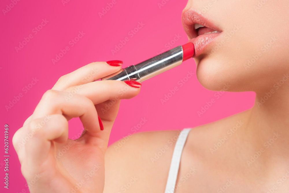 Applying lipstick. Painting lips with bright lipstick, close up. Pampering, lips correction concept. Glossy lipstick on full plump lip. Woman hand applying lipstick. Applying lipstick. Painting lips with bright lipstick, close up. Pampering, lips correction concept. Glossy lipstick on full plump lip. Woman hand applying lipstick.