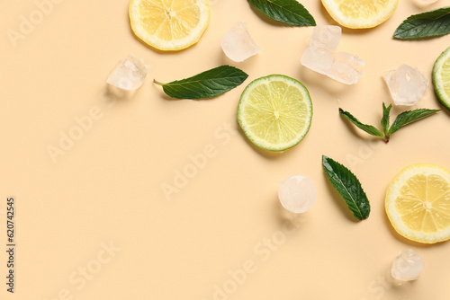 Lime and lemon slices with ice cubes and mint on orange background