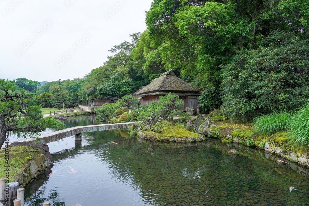 きれいに手入れされた日本庭園と古い茅葺きの日本家屋のコラボ情景