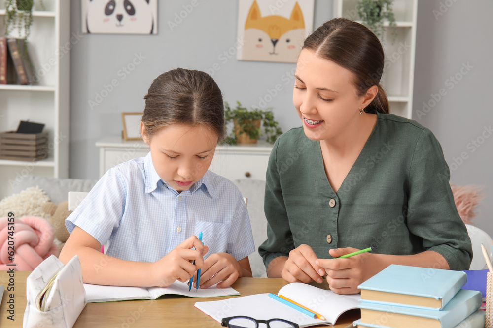 Cute little girl doing lessons with her mother at home Cute little girl doing lessons with her mother at home