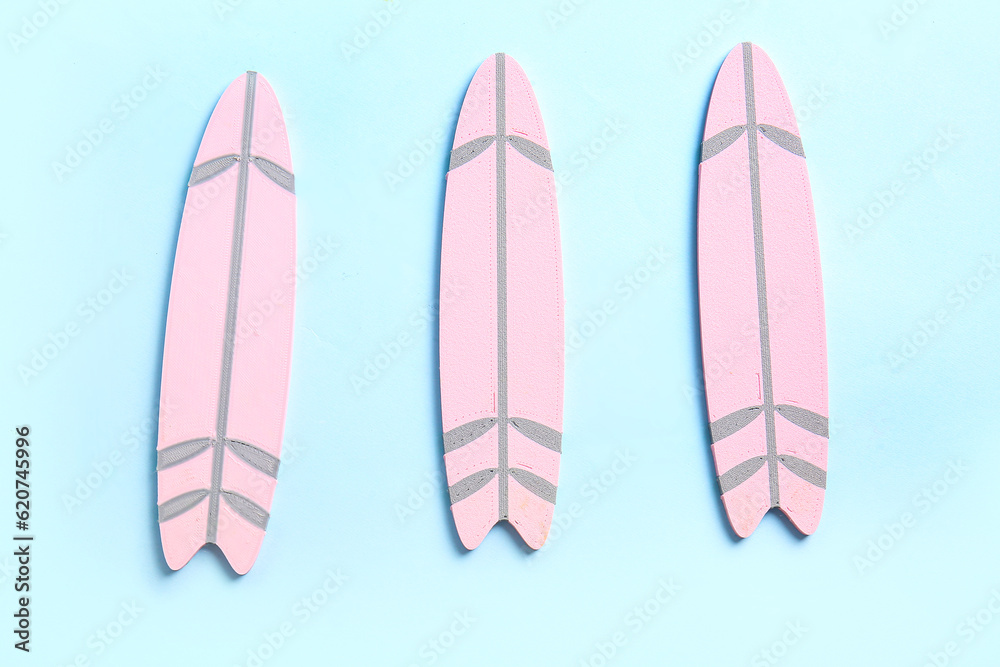 Mini pink surfboards on blue background Mini pink surfboards on blue background