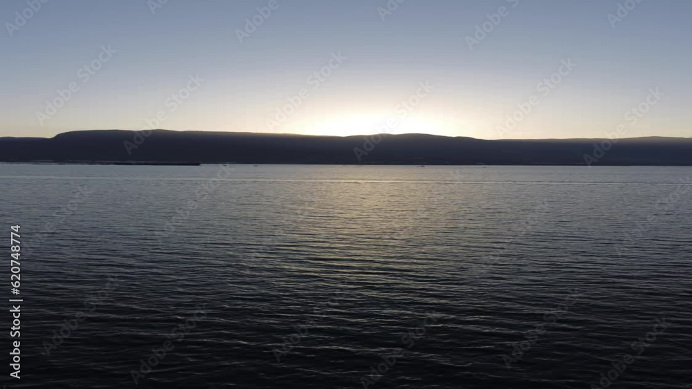 por do sol  atras das montanhas com mar 