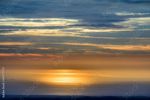 The sky and sea are orange and gold. Ships and dynamic clouds. At dusk  the scenery of the seaside in Miaoli County.