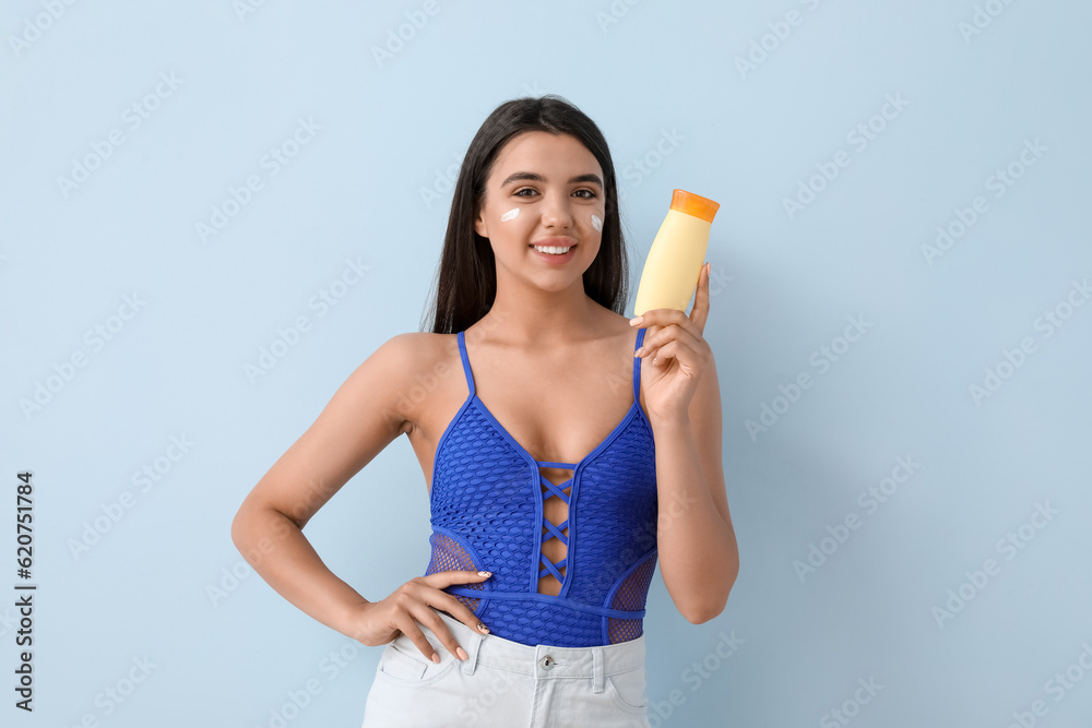 Beautiful young woman with sunscreen cream on light background Beautiful young woman with sunscreen cream on light background