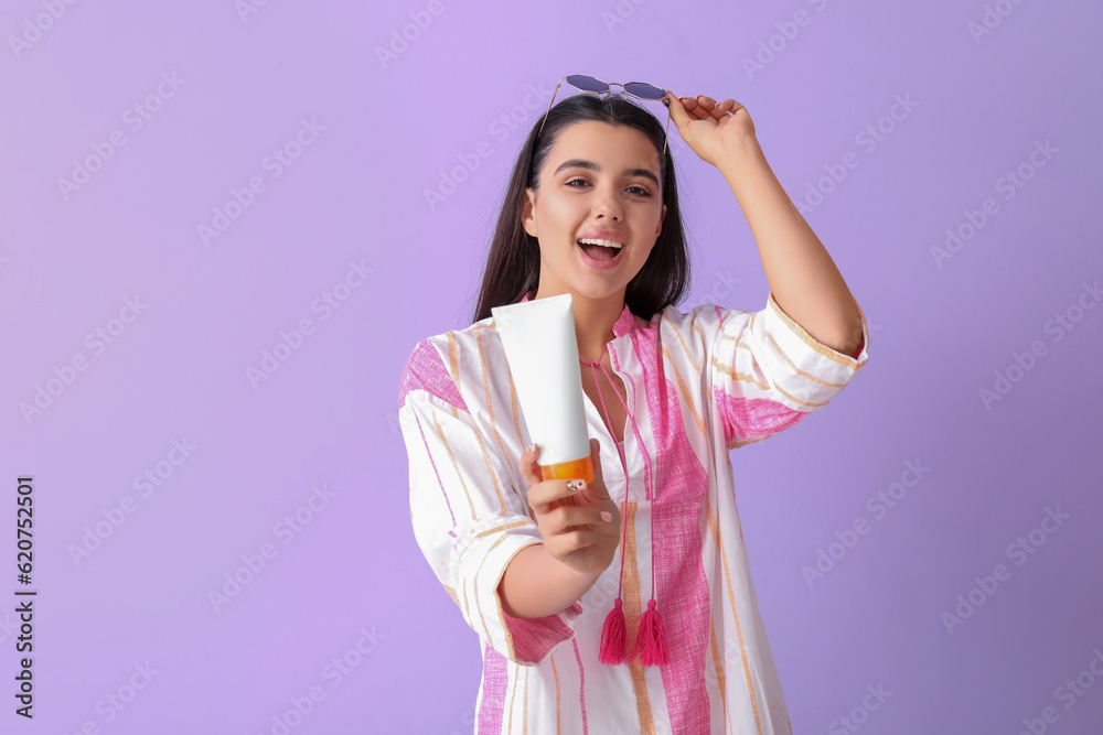 Beautiful young woman with sunscreen cream on lilac background Beautiful young woman with sunscreen cream on lilac background