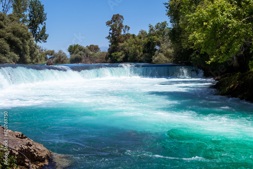 Manavgat waterfall Manavgat River is near the city of Side, 3 km north of Manavgat in Turkey. A wide stream of water falls from a low height. photo