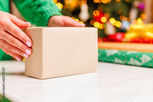 Young woman gets ready for christmas and wrapping a gifts © spyrakot