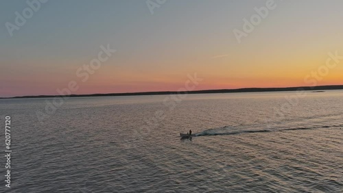 A boat travelling across the water during sunset  photo