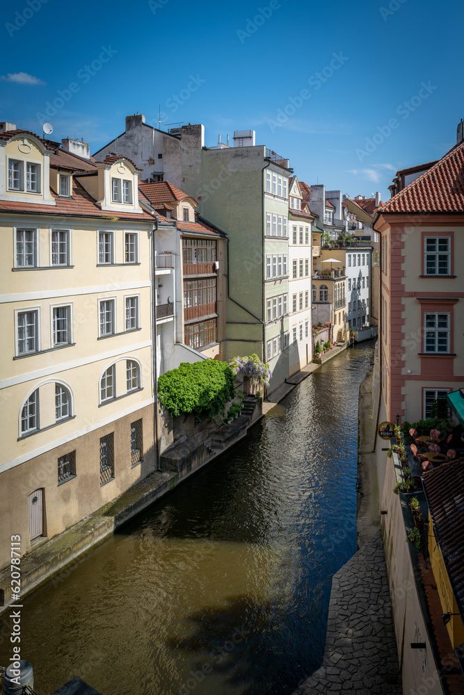 between old historical houses in Prague runs the river Elbe