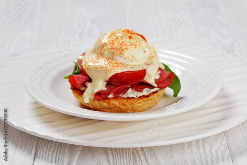 Eggs Benedict on white plate, top view