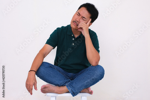 Man sitting on the floor alone looking unhappy with his hand supporting head © Simon