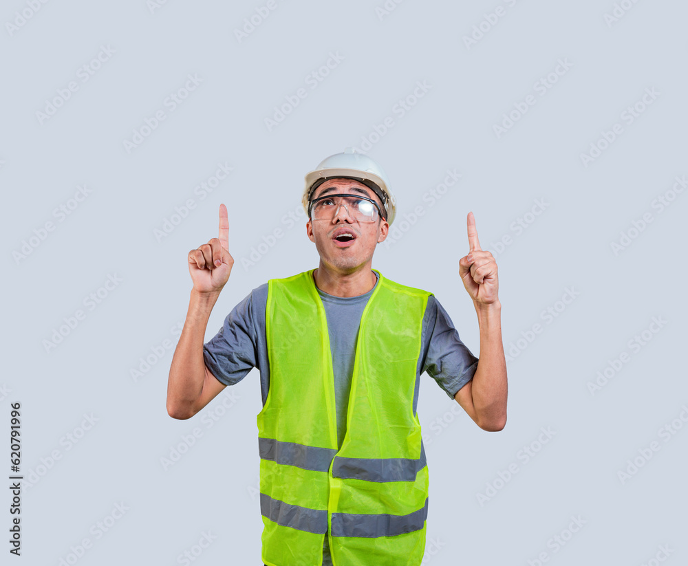 Builder engineer in a vest pointing at an advertisement. Engineer with amazed face pointing to a space Builder engineer in a vest pointing at an advertisement. Engineer with amazed face pointing to a space