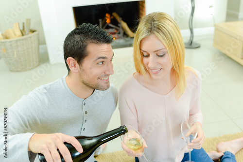 Man pouring partner wine, suggestive expression photo