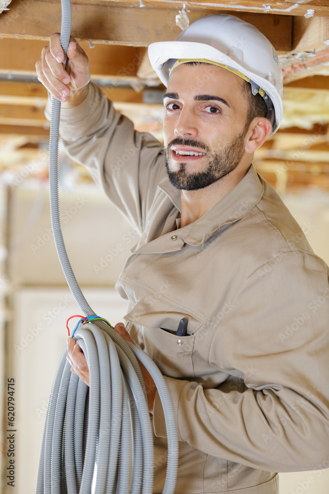 Fototapeta premium portrait of tradesman holding reel of cable