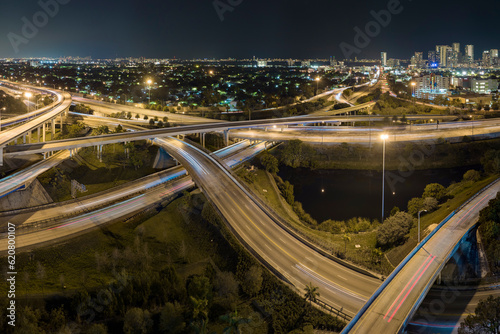 Aerial view of american highway junction at night with fast driving vehicles in Miami  Florida. View from above of USA transportation infrastructure