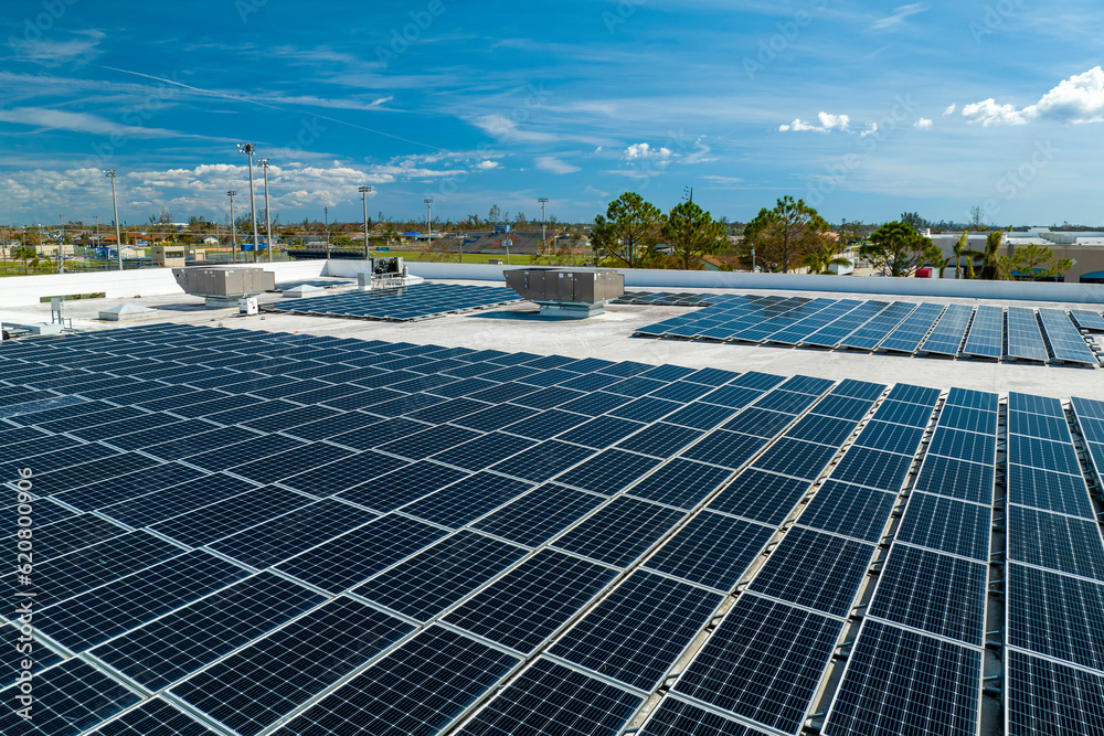 Aerial view of blue photovoltaic solar panels mounted on industrial building roof for producing clean ecological electricity. Production of renewable energy concept Aerial view of blue photovoltaic solar panels mounted on industrial building roof for producing clean ecological electricity. Production of renewable energy concept