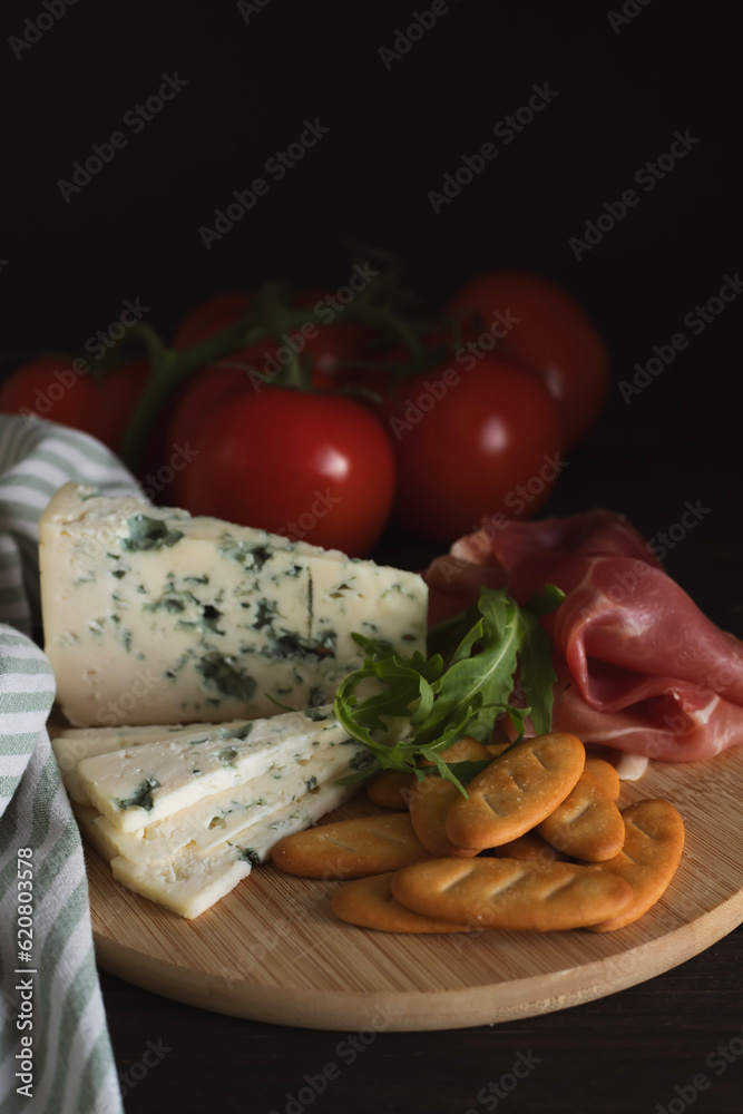 Cheese and cold cuts on a wooden tray on a wooden table Cheese and cold cuts on a wooden tray on a wooden table