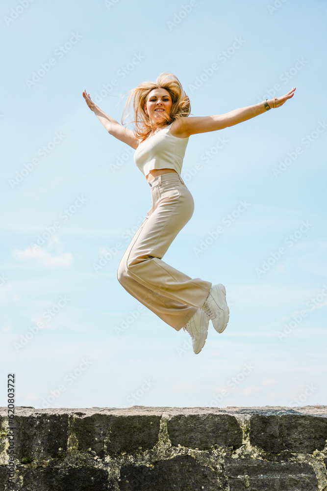 Young blond woman jumping high in the air. Lifestyle, freedom, lightness and happiness.
Young blond woman jumping high in the air. Lifestyle, freedom, lightness and happiness.