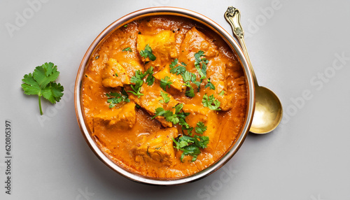 indian butter chicken curry in balti dish top down view and isolated with cilantro garnish