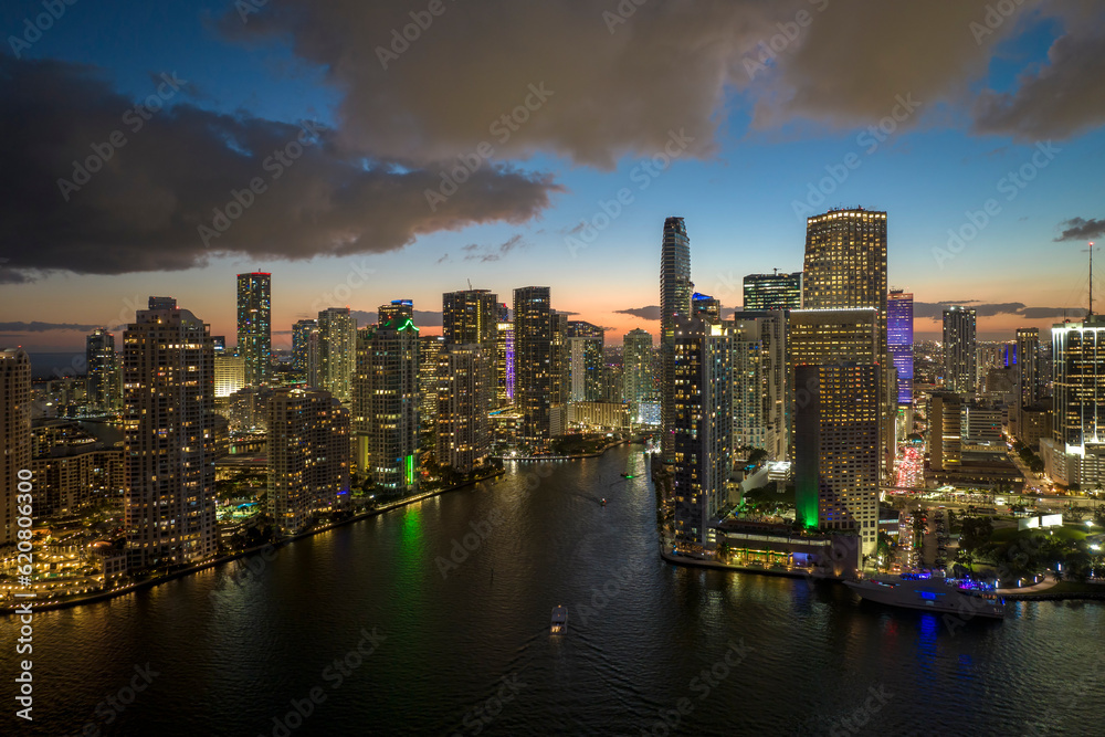 View from above of brightly illuminated high skyscraper buildings in downtown district of Miami Brickell in Florida, USA. American megapolis with business financial district at night