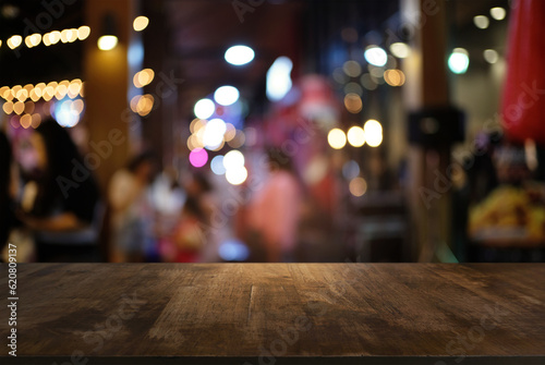 Empty wood table top and blur of night market background/selective focus .For montage product display.