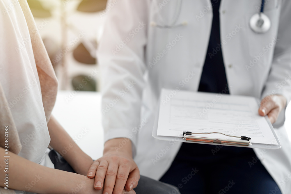 Doctor and child patient. The physician is holding clipboard and reassuring a boy. The concept of ideal health in medicine Doctor and child patient. The physician is holding clipboard and reassuring a boy. The concept of ideal health in medicine
