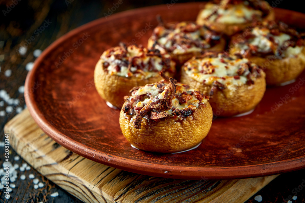 Mushrooms with bacon and cheese baked on the grill in a clay dish. Georgian cuisine Mushrooms with bacon and cheese baked on the grill in a clay dish. Georgian cuisine