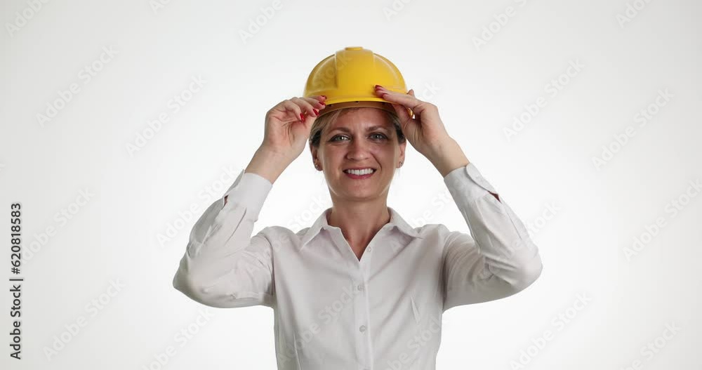 Beautiful female builder puts on yellow helmet. Construction repair and reconstruction of house or apartment Beautiful female builder puts on yellow helmet. Construction repair and reconstruction of house or apartment