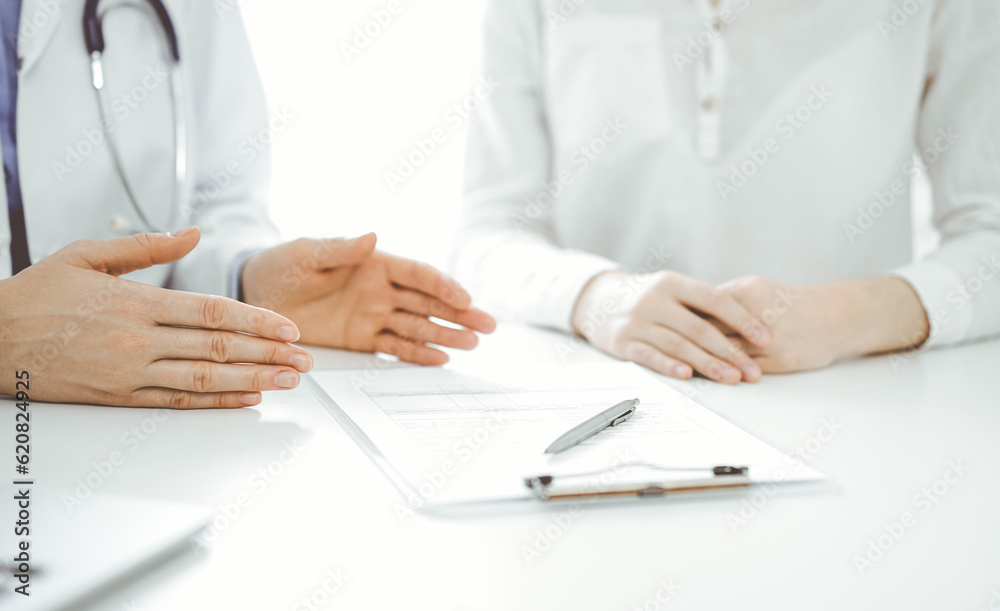 Doctor and patient discussing current health questions while sitting near of each other at the table in clinic, just hands closeup. Medicine concept Doctor and patient discussing current health questions while sitting near of each other at the table in clinic, just hands closeup. Medicine concept