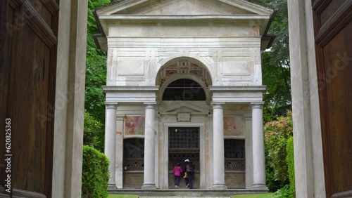 A mother and her little daughter carrying a teddy bear visiting the sacred mountain of Varallo christian devotional complex, a unesco world heritage site near the town of Varallo Sesia in Italy photo