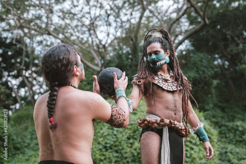 Portrait of two indigenous men with mayan garments and a rubber ball photo