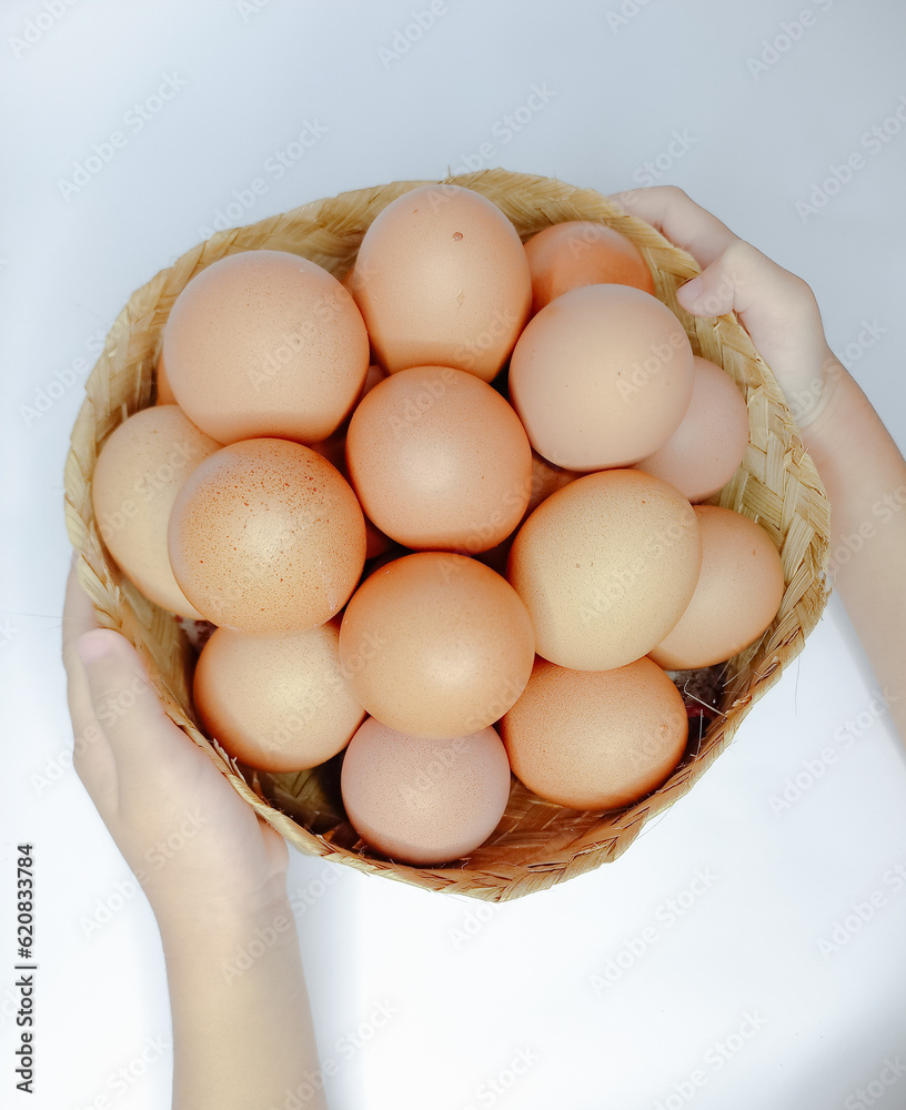 A person Holding Wire Basket of Fresh Chicken Eggs, representing the importance of wellbeing through food and drink. A person Holding Wire Basket of Fresh Chicken Eggs, representing the importance of wellbeing through food and drink.