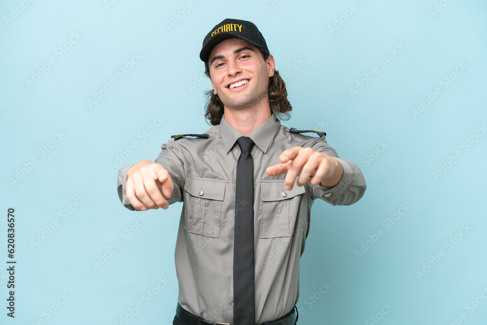 Young safeguard man isolated on blue background points finger at you while smiling Young safeguard man isolated on blue background points finger at you while smiling