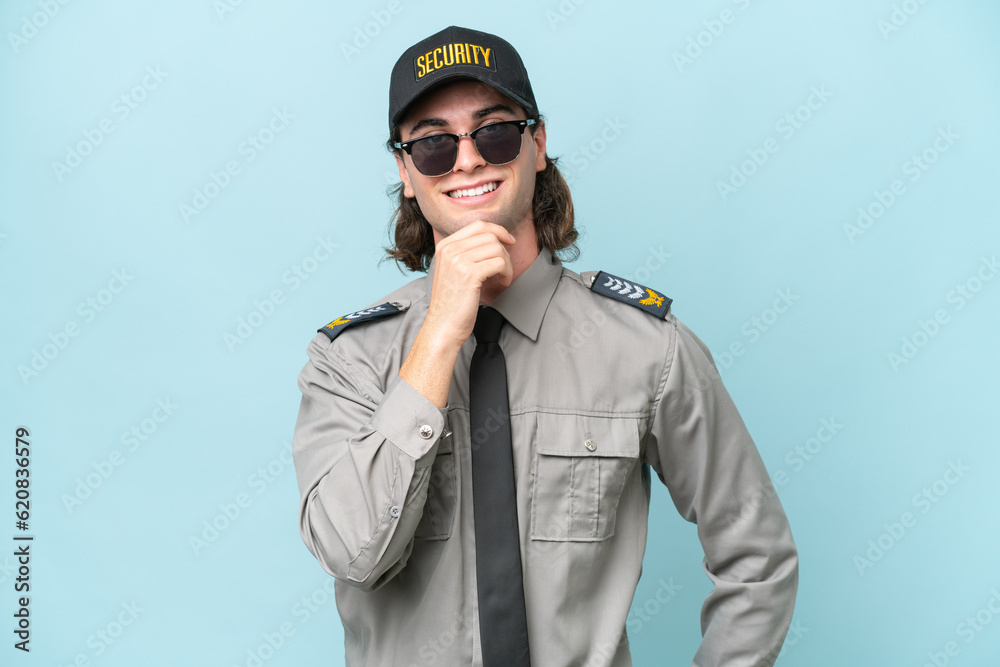 Young safeguard man isolated on blue background with glasses and smiling Young safeguard man isolated on blue background with glasses and smiling