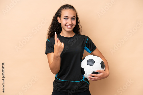 Young football player woman isolated on beige background doing coming gesture © luismolinero
