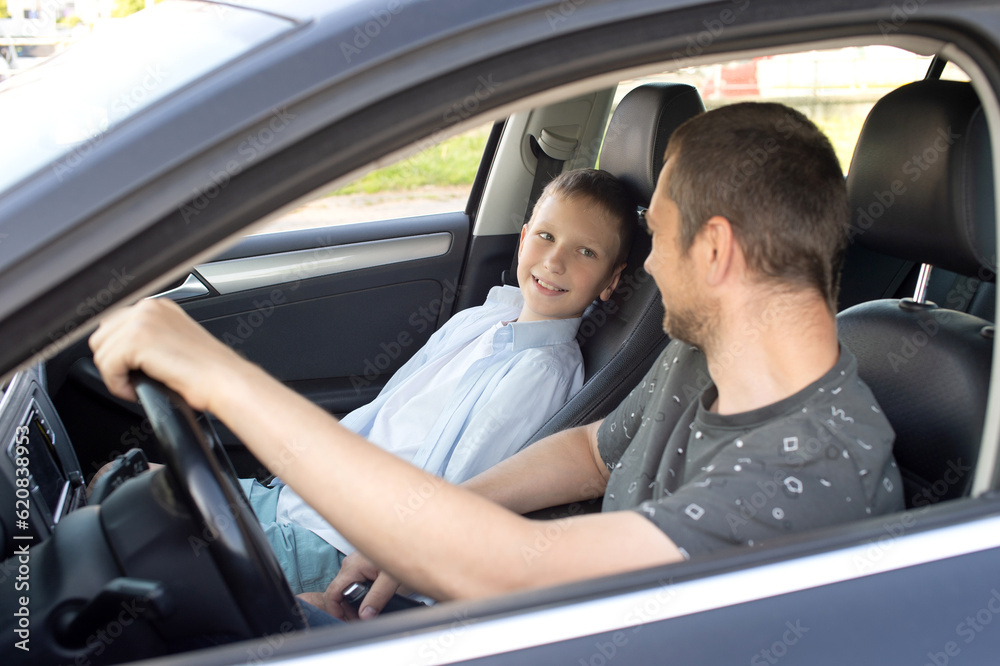 Dad sits with the child in the car and holds the steering wheel. Child in the front seat Dad sits with the child in the car and holds the steering wheel. Child in the front seat